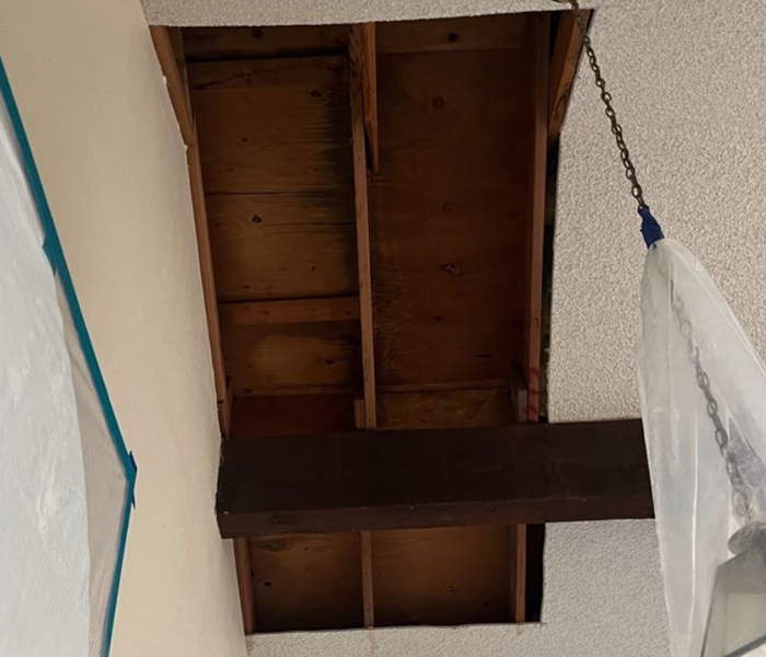 A water-damaged ceiling with a part of it taken out and is empty inside