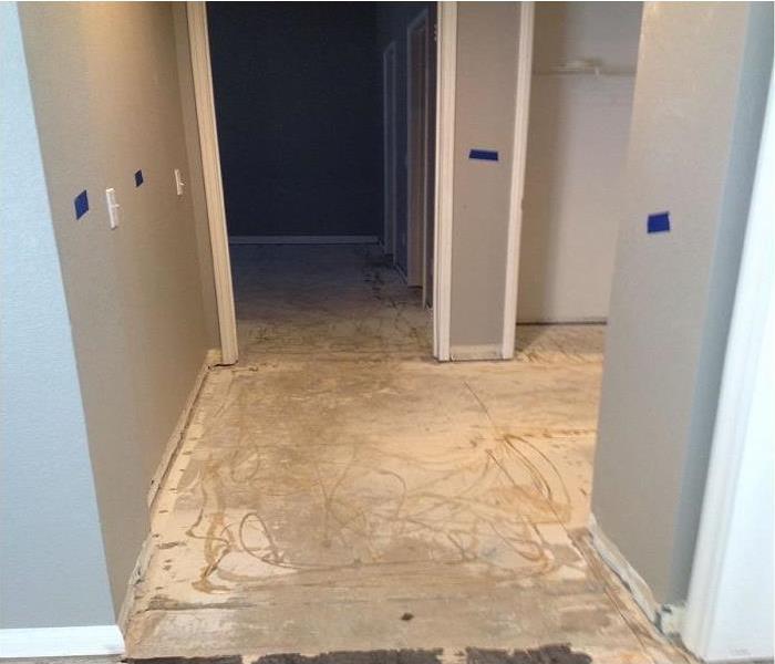 hallway in home with the floors removed showing concrete