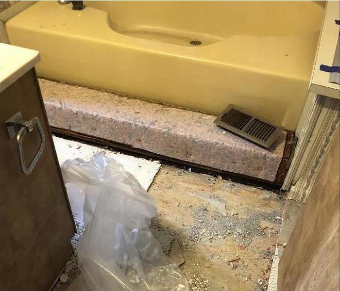 bathroom with yellow tub and floors demos from water damage 