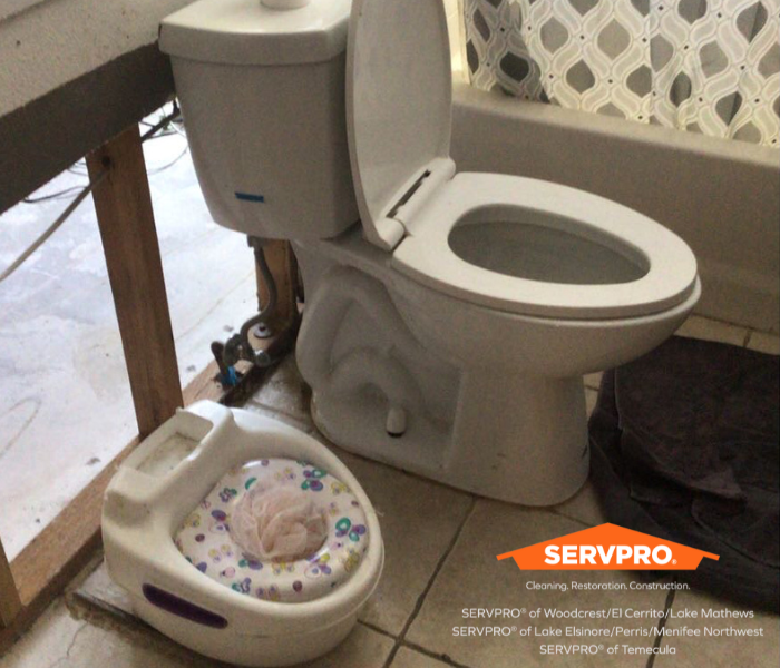 picture is of a toilet and a potty training toilet in a bathroom